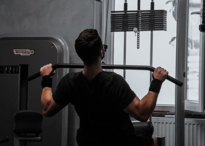 A man working out on a lat pulldown machine in a gym, focusing on strength building.